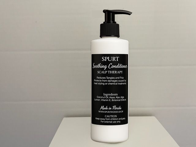 White bottle of conditioner with a black label describing the product.